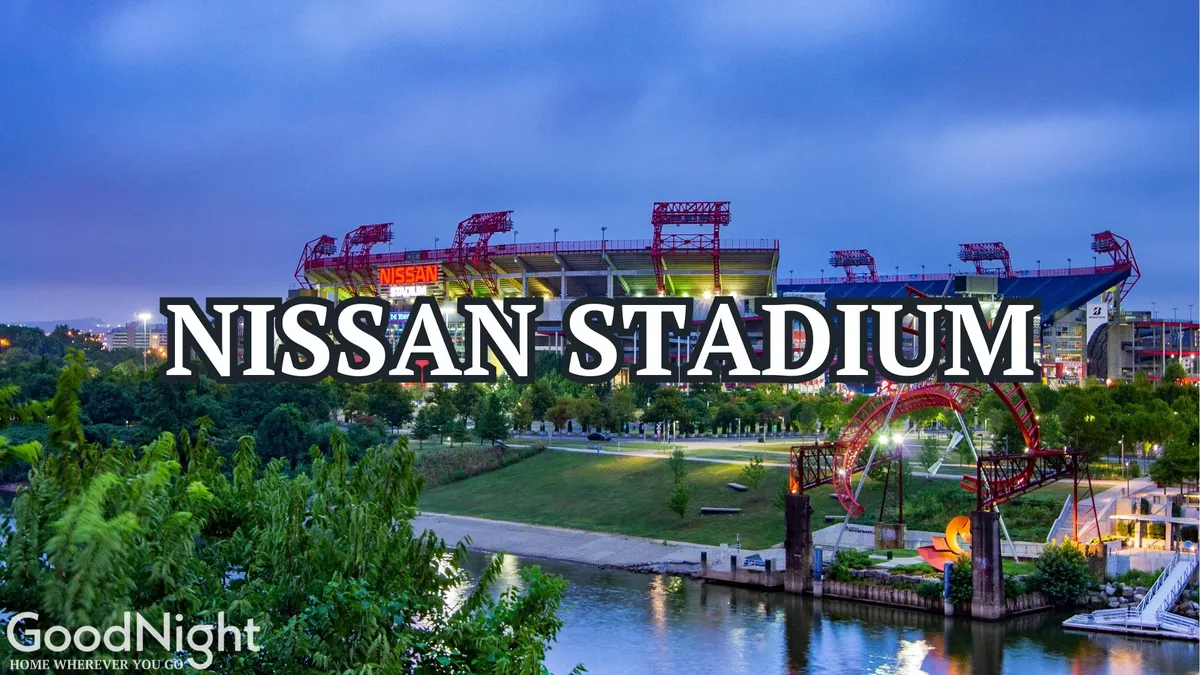 This exterior image captures the vibrant scene around Nissan Stadium, showcasing the riverfront park, the city skyline, and people enjoying outdoor activities. The wide view highlights the energetic spirit of downtown Nashville and the opportunities for walking, events, and communal fun.