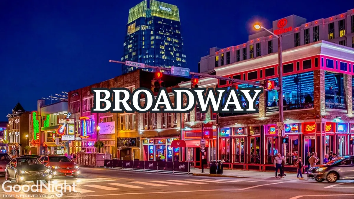 A bustling Nashville street illuminated by vibrant neon lights, with crowds of people moving between various storefronts and restaurants. The illuminated signage and energy in the scene evoke the lively nightlife and entertainment that Nashville is known for.