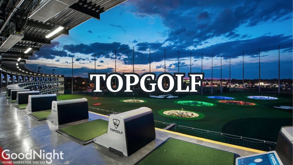 A lively evening view of Topgolf, with friends gathered in the open golf bays, colorful targets illuminated under the night sky, and groups socializing between rounds. The setting is vibrant and energetic, perfect for group outings.